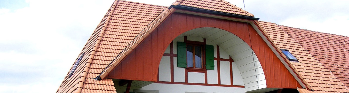 Typischer, unten ausgehöhlter Bogengiebel eines Berner Bauernhauses.